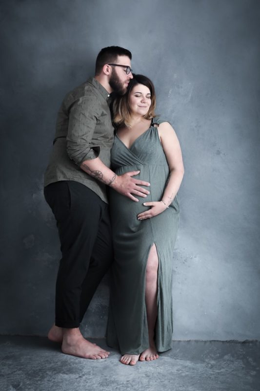 photo de grossesse en couple devant fond photo peint à la main