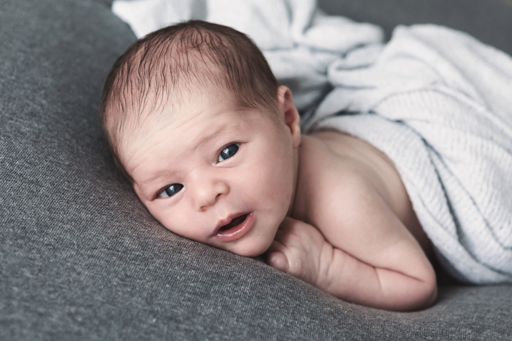 bébé éveillé regarde l'appareil photo