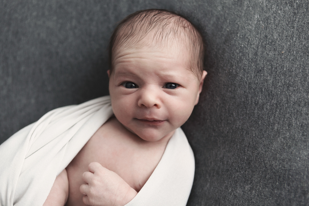 bébé éveillé regarde l'appareil photo