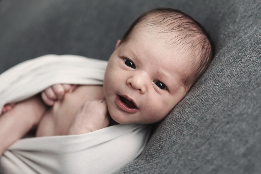 bébé éveillé regarde l'appareil photo